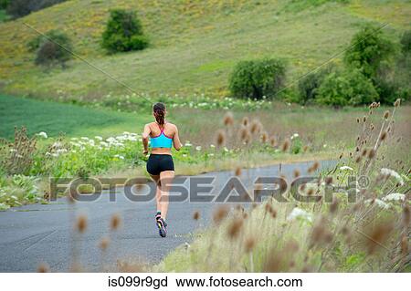 Young woman running in rural setting View Large Photo Image Stock Image - Young woman running in rural setting. Fotosearch