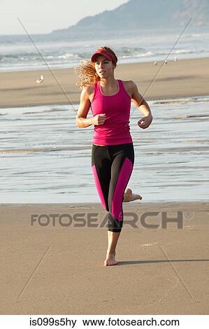 Stock Photo - Young woman running on beach. Fotosearch