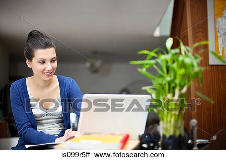 Young woman working from home on laptop View Large Photo Image Stock Image - Young woman working from home on laptop. Fotosearch