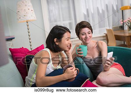 Young women looking at smartphone View Large Photo Image Stock Image - Young women looking at smartphone. Fotosearch