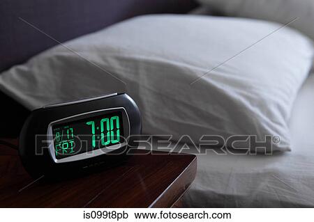 Stock Image - Alarm clock by bed. Fotosearch