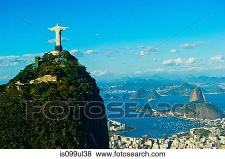 Stock Photo - Christ the Redeemer statue overlooking Rio de Janeiro and Sugarloaf Mountain, Brazil. Fotosearch