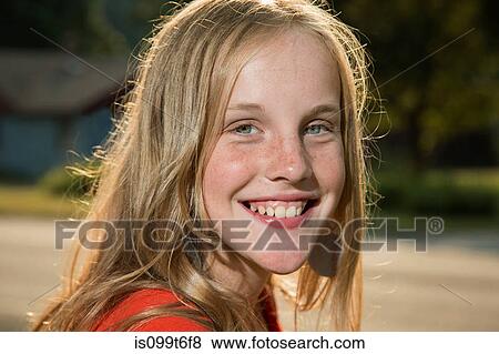 Stock Photo - Close up portrait of blonde girl looking at camera smiling. Fotosearch