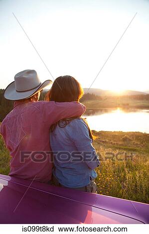 Stock Image - Couple looking at sunset. Fotosearch