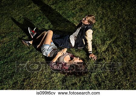 Couple lying on grass at night, high angle View Large Photo Image Stock Photo - Couple lying on grass at night, high angle. Fotosearch