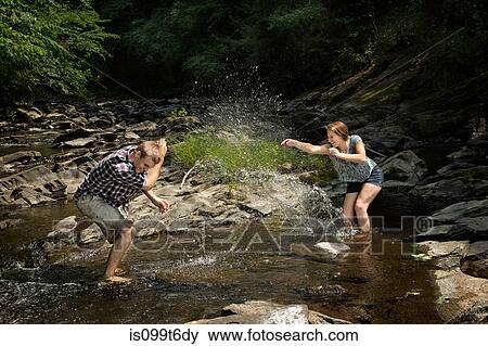 Couple playing in river View Large Photo Image Stock Photo - Couple playing in river. Fotosearch