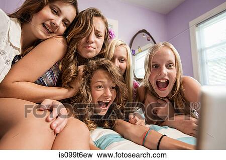 Stock Photo - Excited girls looking at digital tablet. Fotosearch