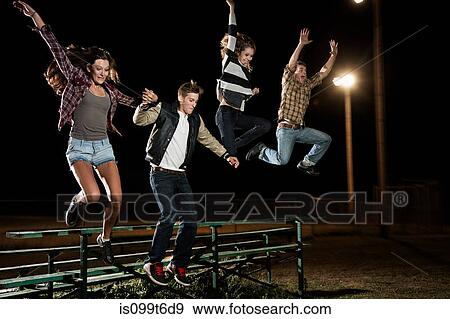 Four friends jumping over bleachers at night View Large Photo Image Stock Photo - Four friends jumping over bleachers at night. Fotosearch