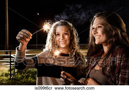 Stock Photography - Friends holding sparklers. Fotosearch