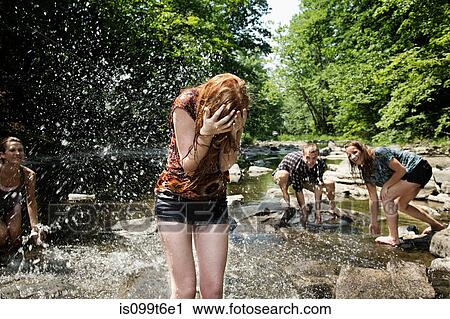Stock Image - Friends playing in river. Fotosearch