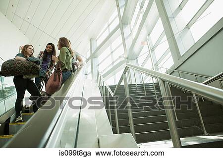 Friends travelling on escalator View Large Photo Image Stock Image - Friends travelling on escalator. Fotosearch