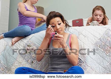 Girl applying makeup in bedroom View Large Photo Image Stock Photography - Girl applying makeup in bedroom. Fotosearch