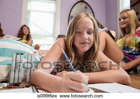 Stock Photo - Girl drawing in notebook. Fotosearch