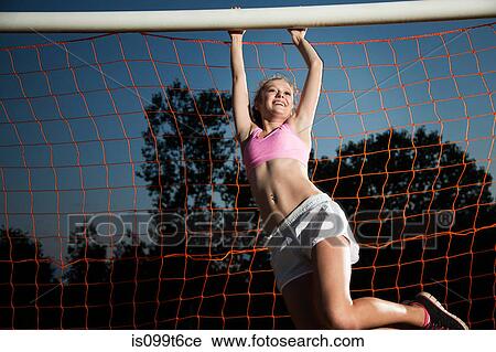 Stock Image - Girl hanging from soccer goal. Fotosearch