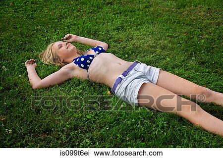 Girl lying on grass, high angle View Large Photo Image Stock Image - Girl lying on grass, high angle. Fotosearch
