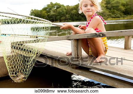 Girl on jetty with frog in fishing net View Large Photo Image Stock Photo - Girl on jetty with frog in fishing net. Fotosearch