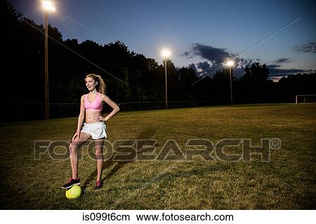 Picture - Girl on soccer pitch at night. Fotosearch