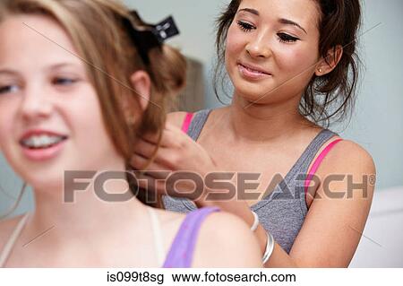 Girl styling friend's hair View Large Photo Image Stock Image - Girl styling friend's hair. Fotosearch