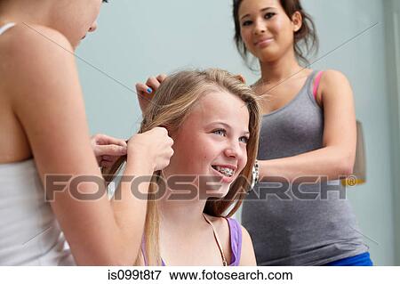 Stock Photo - Girls braiding friend's hair. Fotosearch