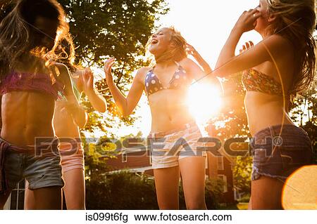 Stock Image - Girls dancing in garden. Fotosearch
