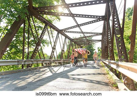 Group of friends running on bridge holding american flag View Large Photo Image Picture - Group of friends running on bridge holding american flag. Fotosearch