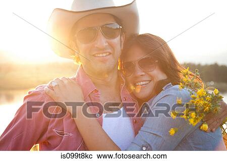 Happy couple in sunlight with flowers View Large Photo Image Stock Image - Happy couple in sunlight with flowers. Fotosearch