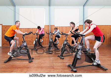 Male instructor leading female spinning class View Large Photo Image Stock Photo - Male instructor leading female spinning class. Fotosearch