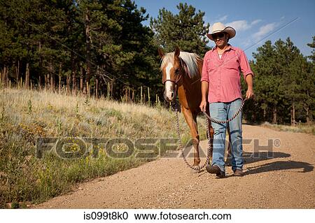 Man and horse walking on dirt road View Large Photo Image Stock Image - Man and horse walking on dirt road. Fotosearch