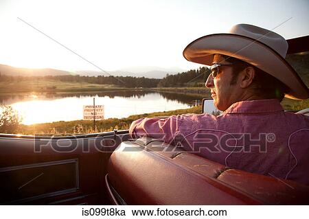 Man in cowboy hat, looking at lake from his car View Large Photo Image Stock Image - Man in cowboy hat, looking at lake from his car. Fotosearch