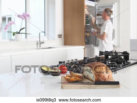 Stock Image - Man in kitchen, preparing food. Fotosearch