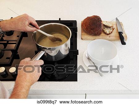 Man stirring saucepan of soup on hob View Large Photo Image Stock Photo - Man stirring saucepan of soup on hob. Fotosearch