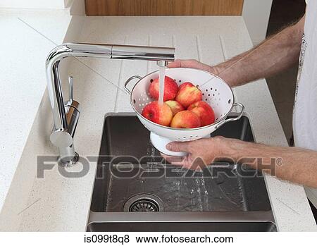 Stock Photo - Man washing apples. Fotosearch