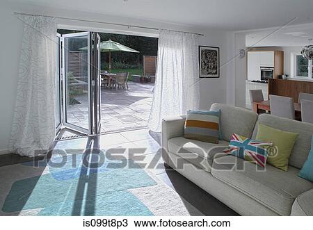 Stock Image - Open plan living area with open patio doors. Fotosearch
