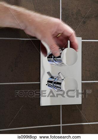 Stock Photography - Person turning a knob in the shower. Fotosearch