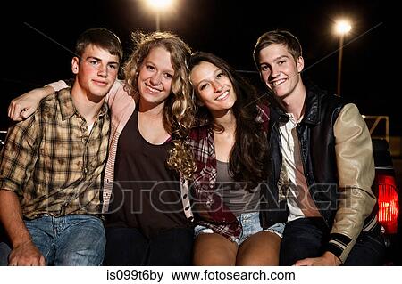 Stock Photo - Portrait of four friends with arms around each other. Fotosearch