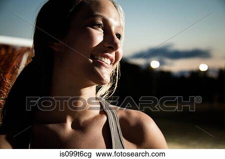 Stock Image - Portrait of girl smiling, at night. Fotosearch