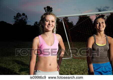 Stock Photo - Portrait of two girls on soccer pitch at night. Fotosearch