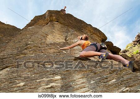 Stock Photo - Rock climbers scaling rock, Ruapuke, Raglan, New Zealand. Fotosearch