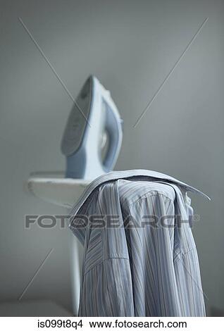 Shirt and iron on ironing board View Large Photo Image Picture - Shirt and iron on ironing board. Fotosearch
