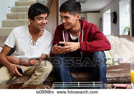 Stock Photo - Teenage boys looking at cellphone. Fotosearch