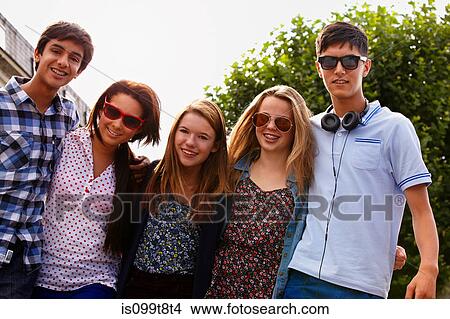 Picture - Teenage friends looking at camera. Fotosearch