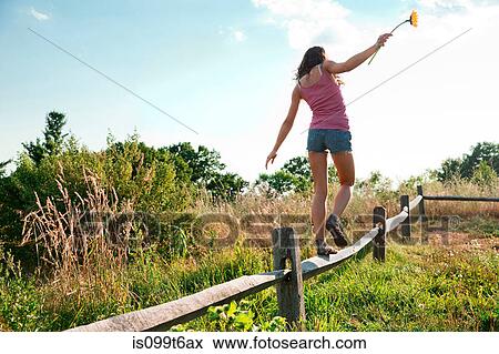 Teenage girl balancing on wooden fence View Large Photo Image Stock Photo - Teenage girl balancing on wooden fence. Fotosearch