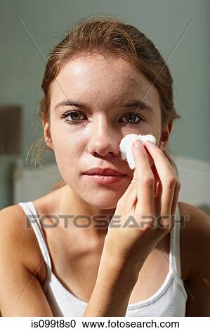 Stock Image - Teenage girl cleansing her face. Fotosearch