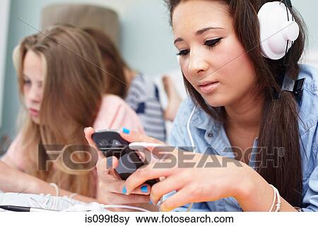 Teenage girl listening to music player View Large Photo Image Stock Photo - Teenage girl listening to music player. Fotosearch