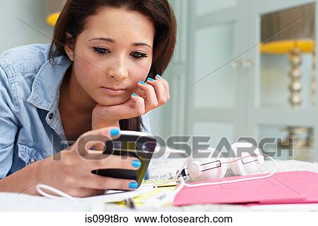 Picture - Teenage girl looking at cellphone. Fotosearch