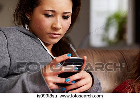 Stock Photograph - Teenage girl looking at cellphone. Fotosearch