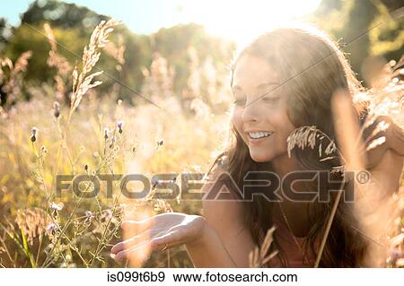 Stock Photo - Teenage girl lying in field, close up. Fotosearch