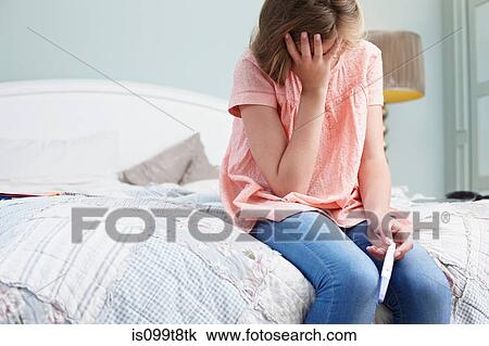 Teenage girl sitting on bed with pregnancy test View Large Photo Image Stock Image - Teenage girl sitting on bed with pregnancy test. Fotosearch