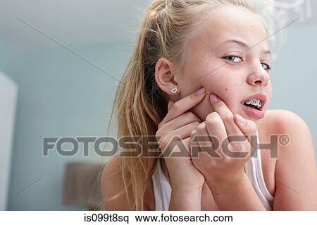 Stock Photography - Teenage girl squeezing a spot. Fotosearch