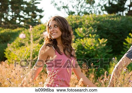Teenage girl walking in field with boyfriend View Large Photo Image Stock Image - Teenage girl walking in field with boyfriend. Fotosearch